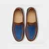 Women's denim driving shoes with brown leather trim, top view on a light grey background.